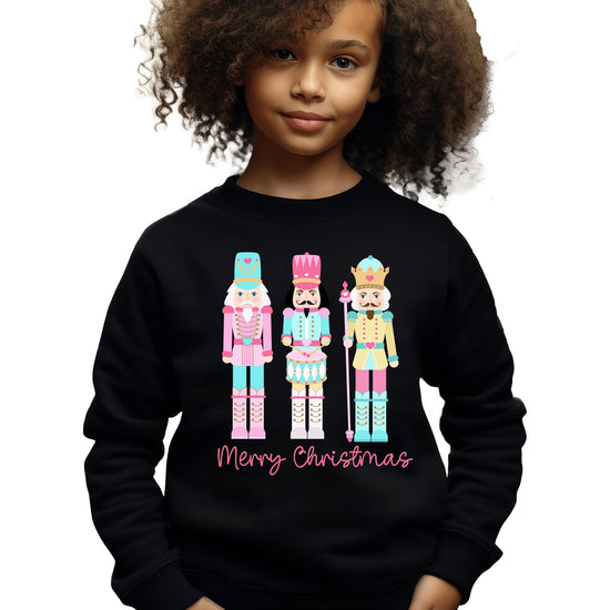 Close-up of pastel nutcracker graphic with Merry Christmas text on holiday sweatshirt