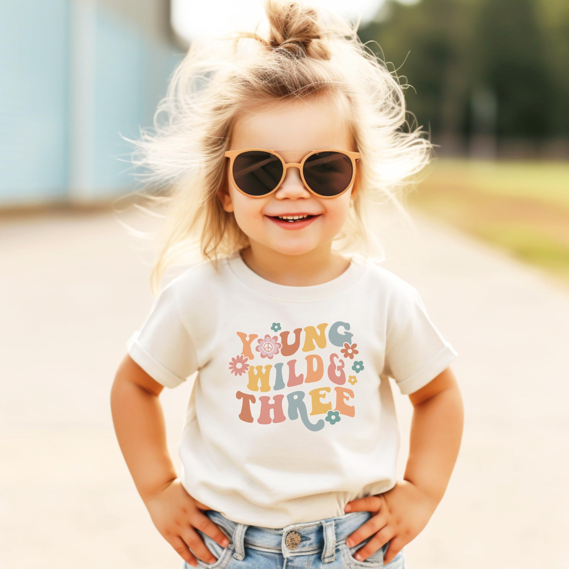 Close-up of Young Wild Three daisy birthday design on toddler shirt