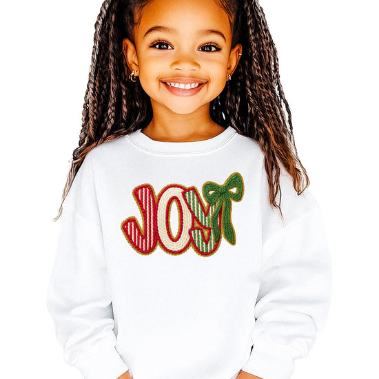 Close-up of JOY holiday sweatshirt showing festive ink-printed faux yarn patch lettering detail