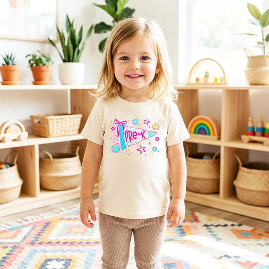 Back to school outfit flat lay featuring girls Pre-K floral pennant tee paired with matching accessories