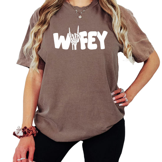 Woman wearing trendy Wifey skeleton Halloween shirt showing fit and style