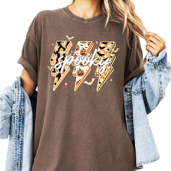 Women's espresso brown oversized graphic tee with spooky lightning bolt design featuring ghosts, pumpkins, and bats