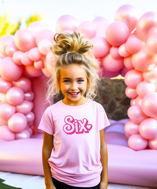 Close-up of Six birthday tee graphic print showing retro font and pink heart design detail