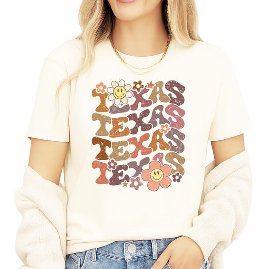Texas retro game day shirt with colorful groovy TEXAS lettering and smiley flower design on natural background