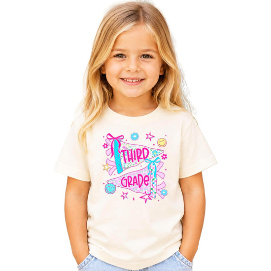 Back to school shirt for girls in pink with third grade floral pennant design, front view flat lay
