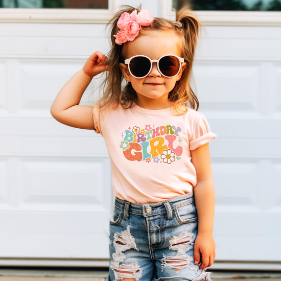Flat lay of birthday girl natural shirt with retro groovy floral design for girls