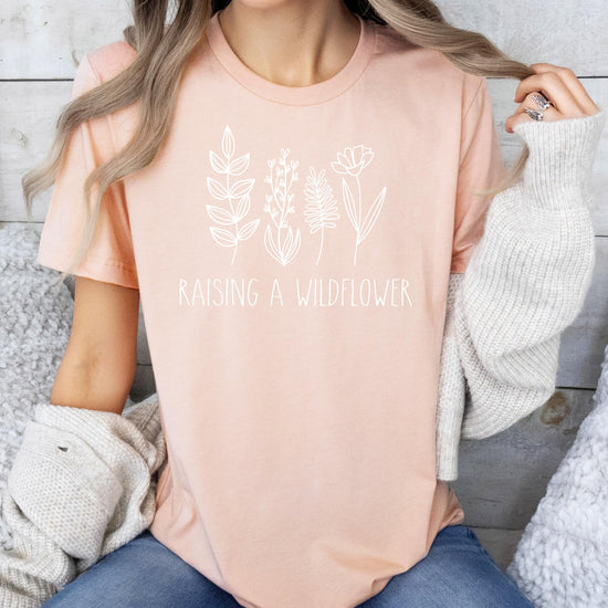 Flat lay of mommy and me wildflower matching shirts in mauve and white