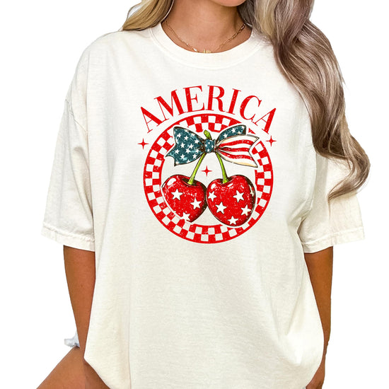 Patriotic cherry bow tee with stars and stripes design on ivory shirt