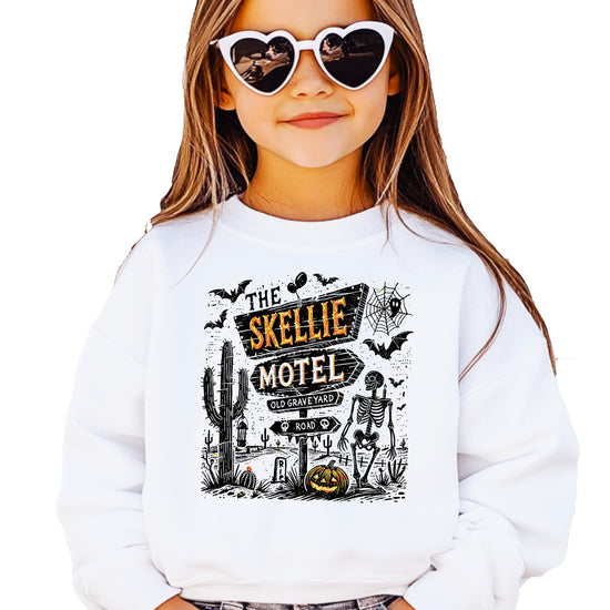 Detail shot of The Skellie Hotel Halloween sweatshirt design featuring glowing pumpkins and skeleton artwork