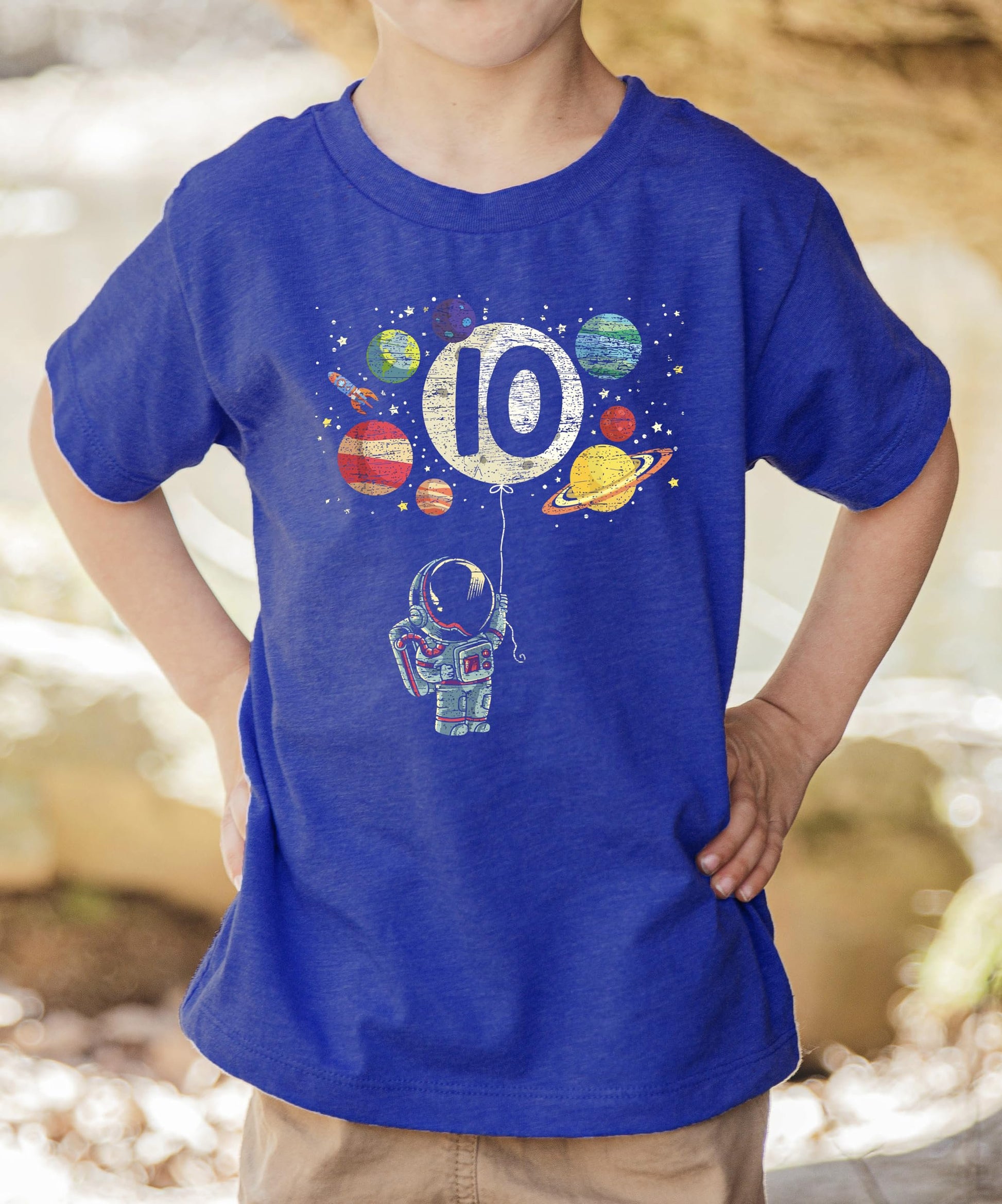 Close-up of astronaut holding number 10 balloon with planets on boys birthday tee