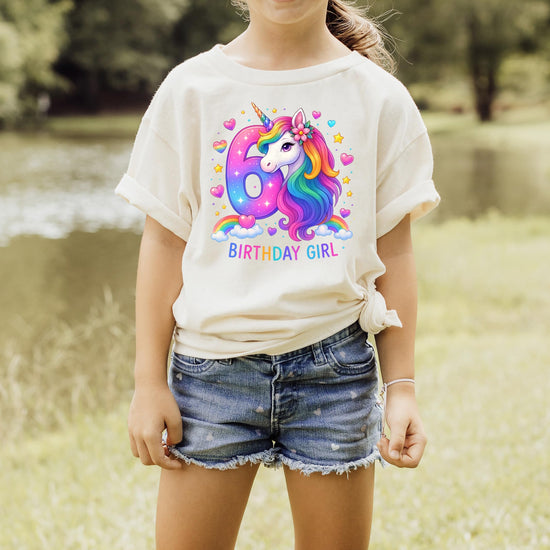 Girls wearing 6th birthday unicorn shirt in pink with rainbow horse party theme graphic
