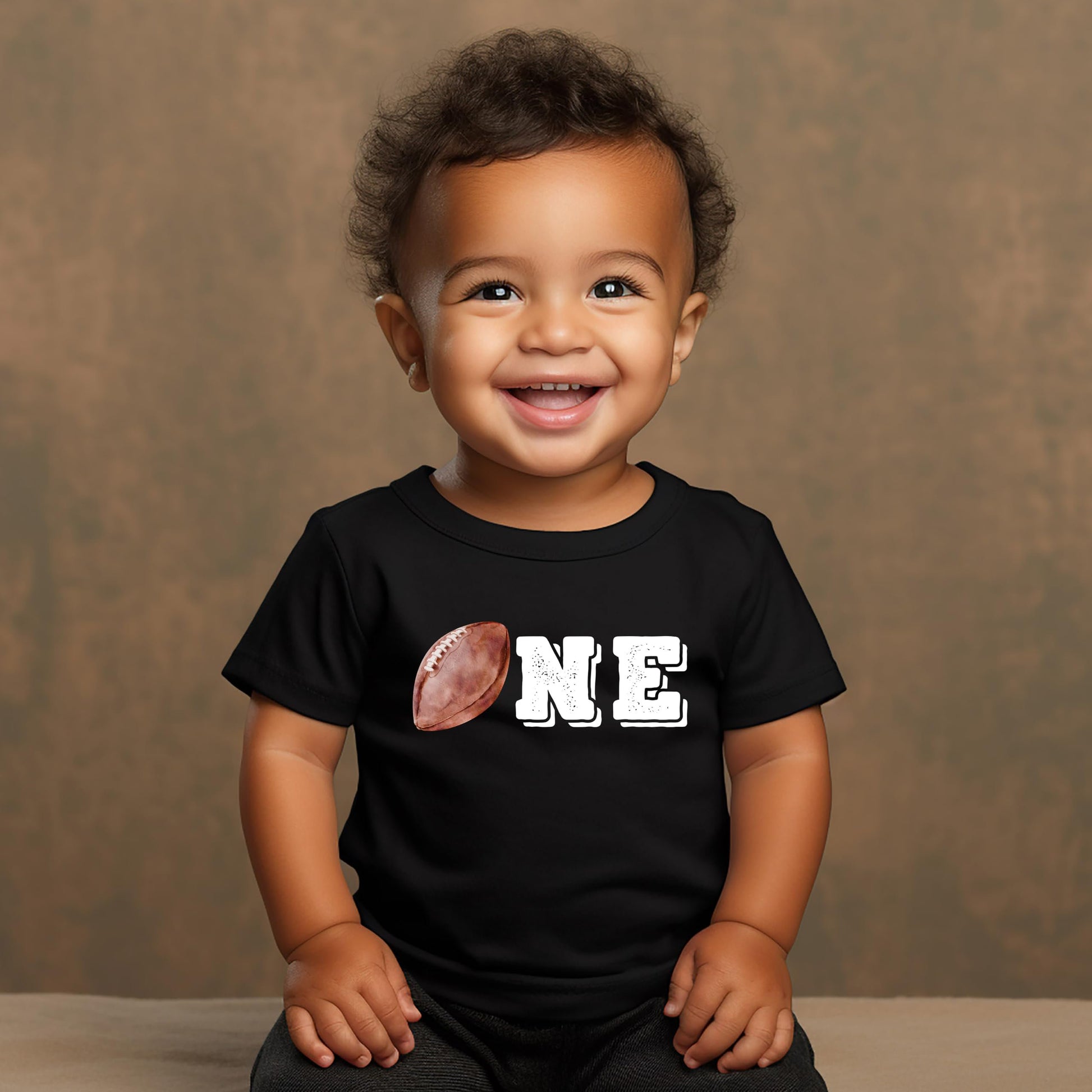 Detail shot of distressed football outline graphic on boys 1st birthday tee