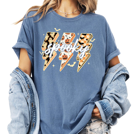 Front view of Spooky Halloween graphic tee with bold lightning bolt filled with pumpkins, bats, and ghosts on dark brown shirt