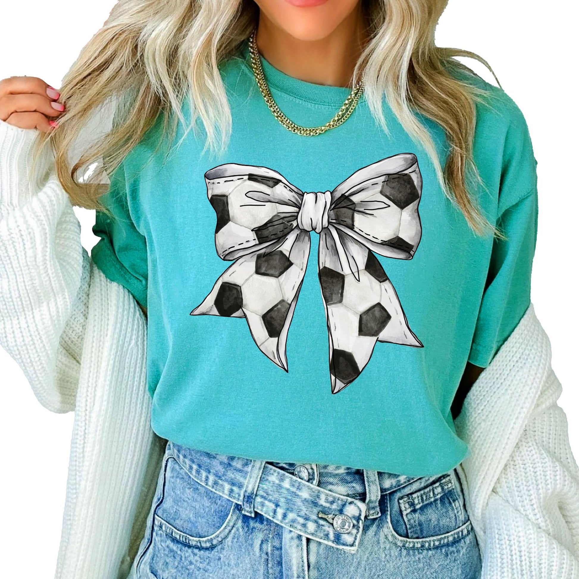 Close-up of coquette bow soccer graphic print on a seafoam oversized tee