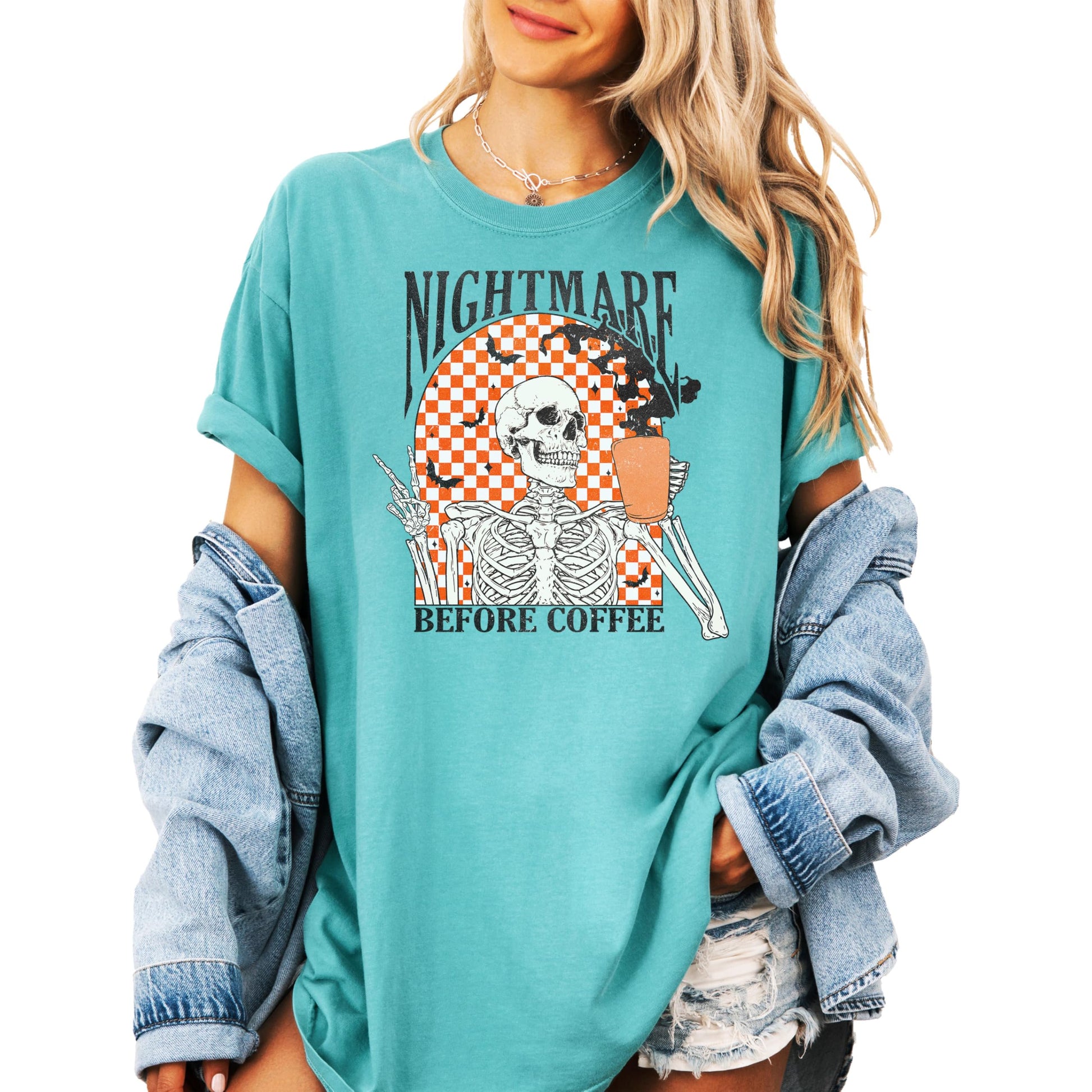 Model wearing Nightmare Before Coffee spooky retro graphic tee in seafoam, styled casually for Halloween season