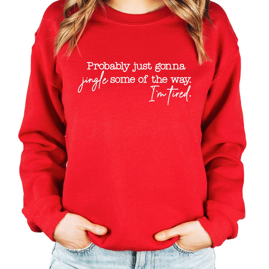 Close-up of Jingle Some of the Way I'm Tired graphic print on a red holiday sweatshirt