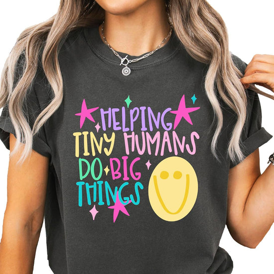 Back or side view of Helping Tiny Humans Do Big Things preschool teacher graphic tee by Olive Loves Apple