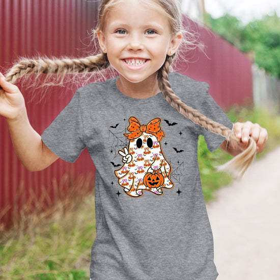 Side view of kids natural Halloween graphic tee with girly ghost and orange bow print