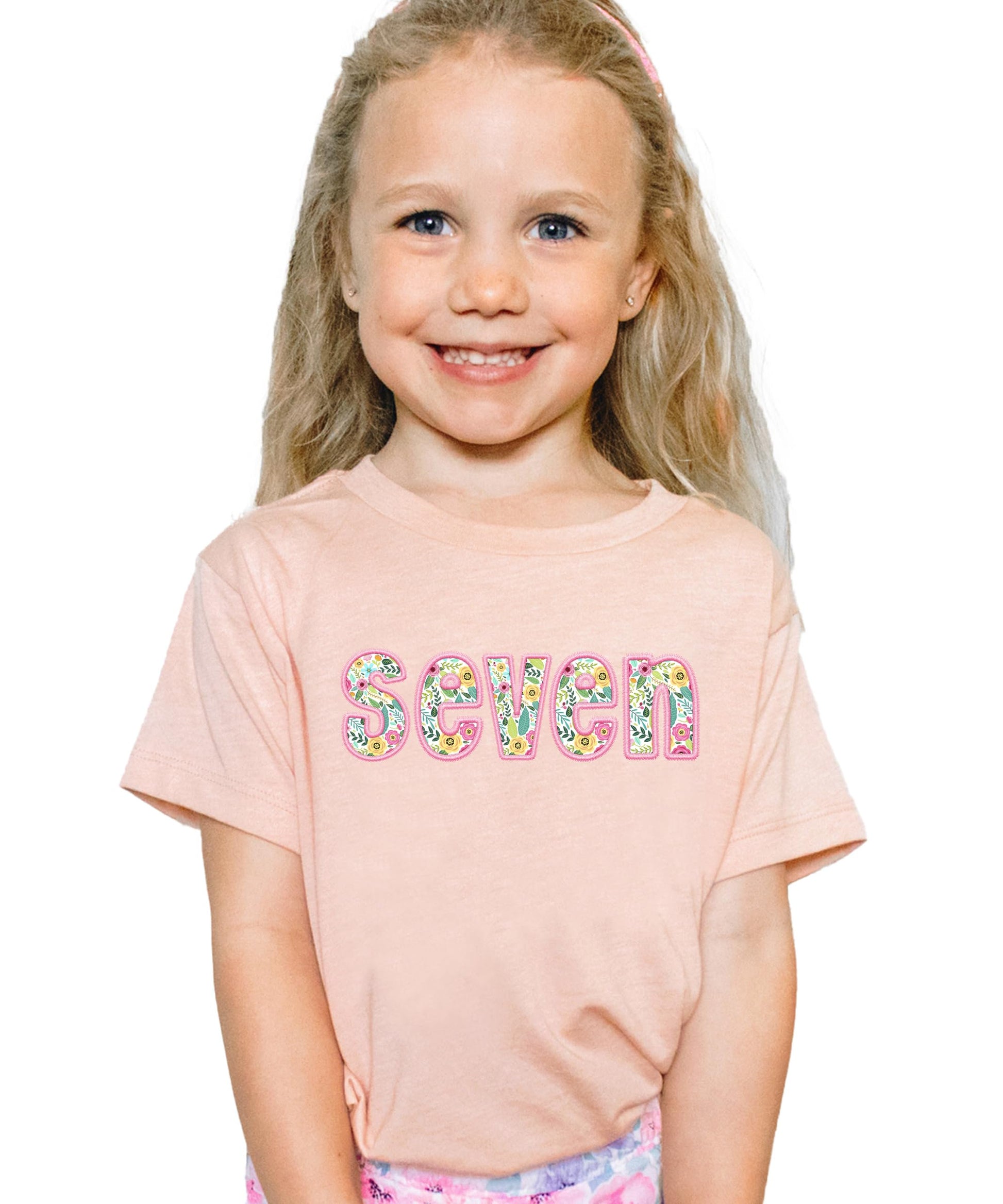 Peach girls birthday shirt with floral embroidered seven design and pink accents