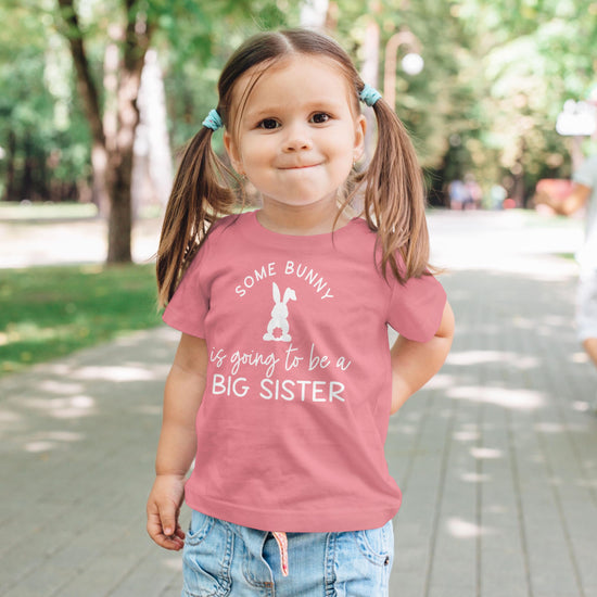 Kids wearing Some Bunny is Going to Be a Big Sister Easter graphic shirt in peach