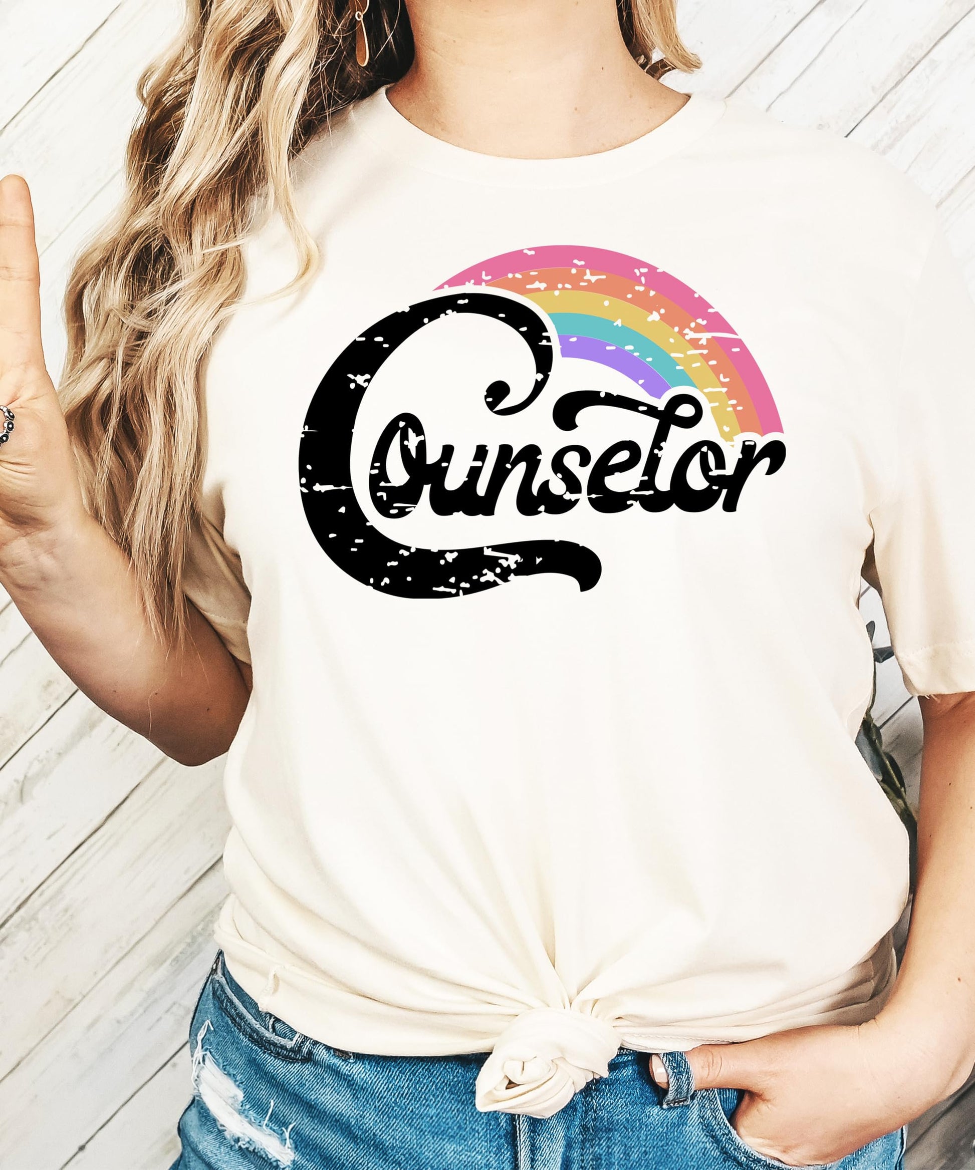 Flat lay of black women's counselor shirt with rainbow graphic design