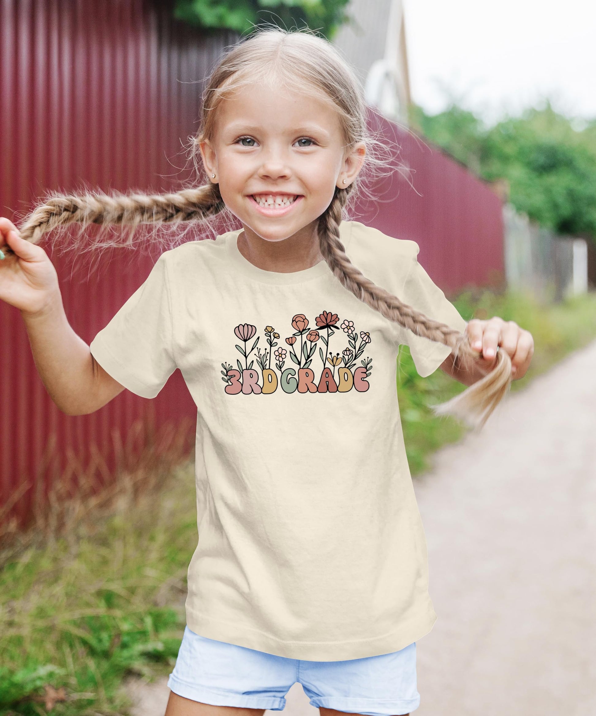 3rd grade girls graphic tee with whimsical flower design, detail shot on military green shirt