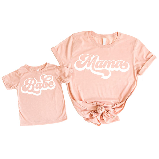 Retro mommy and me matching white graphic tee on peach background, adult women's style