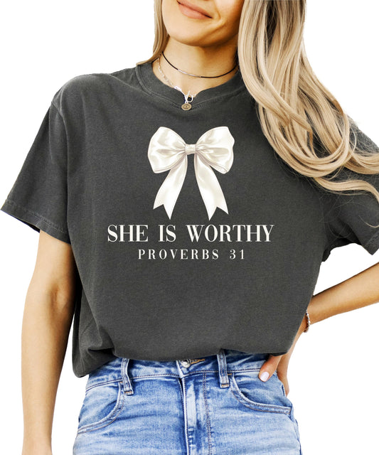 Close-up of She is Worthy Proverbs 31 text design with delicate white satin bow detail
