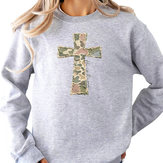 Front view of women's Christian Easter faith sweatshirt with camo cross He Is Risen design