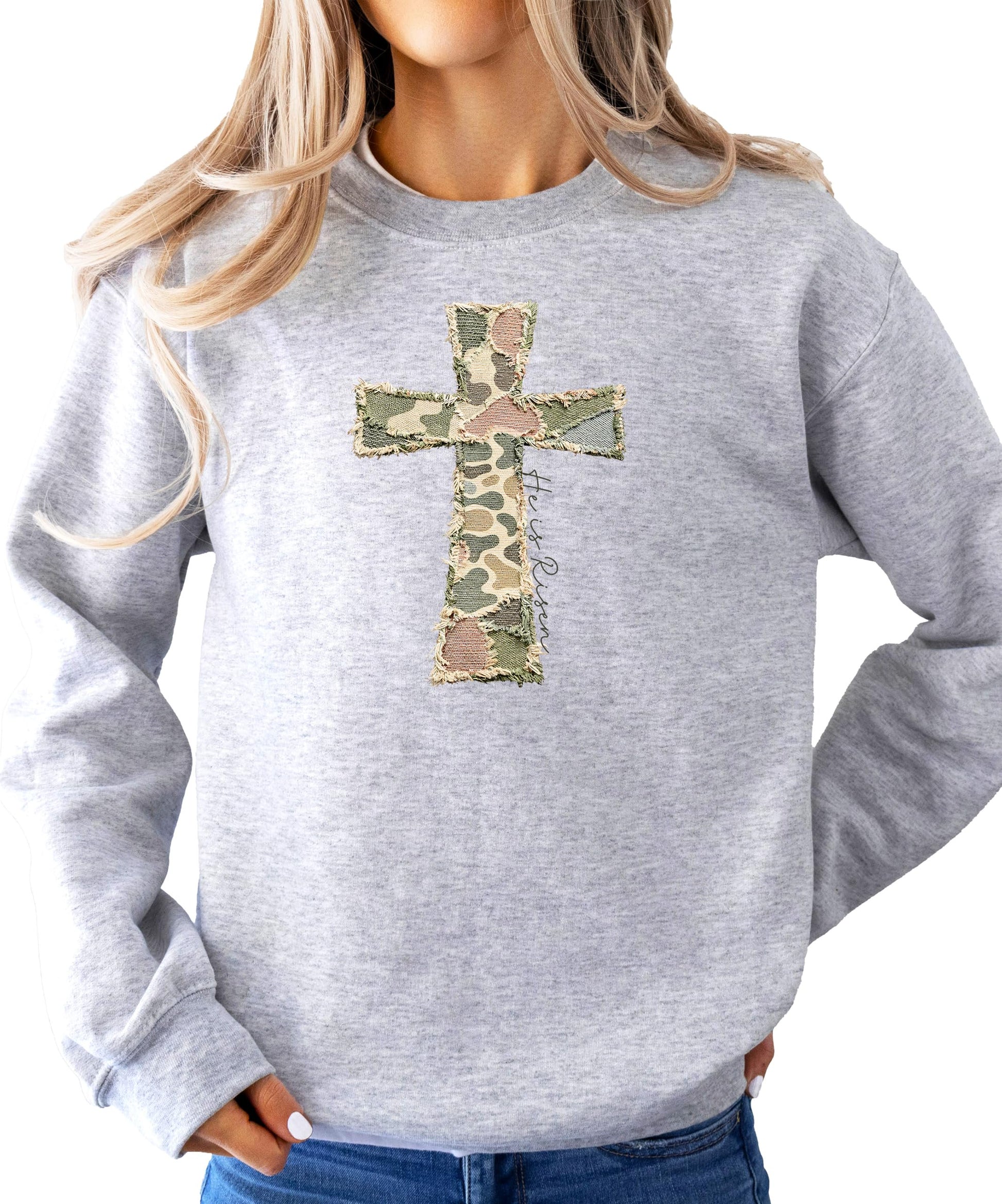 Front view of women's Christian Easter faith sweatshirt with camo cross He Is Risen design