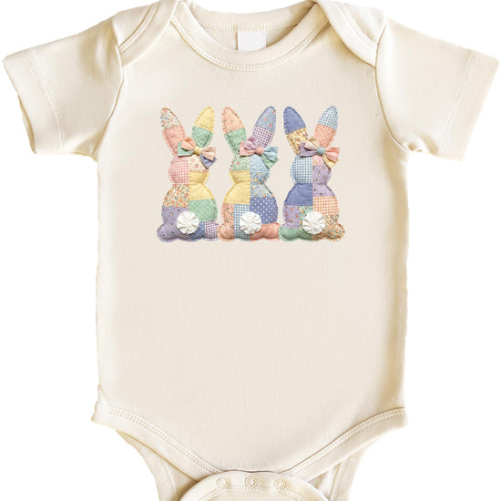 Flat lay of 3 bunnies quilt baby bodysuit in natural cotton color with snap bottom