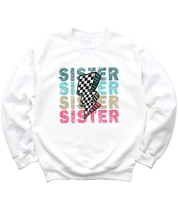 Detail shot of retro checkered lightning bolt centerpiece on girls colorful SISTER sweatshirt