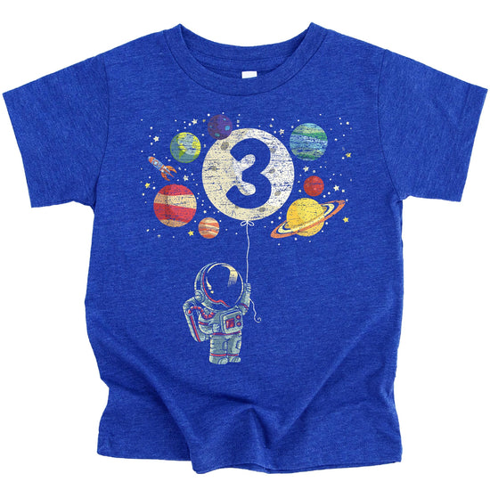 Close-up of space themed 3rd birthday shirt with colorful rocket and planet print