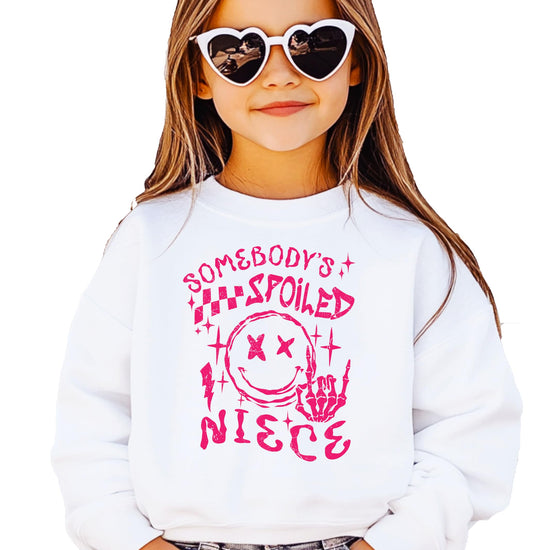 Close-up of Somebody's Spoiled Niece graphic print on pink crewneck sweatshirt for girls