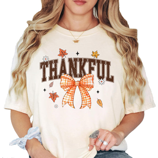 Close-up view of Thankful text with decorative gingham bow detail on seafoam shirt