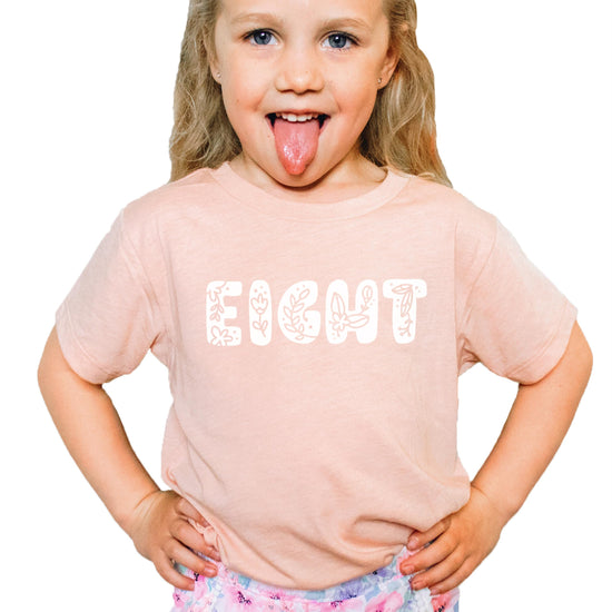 Young girl wearing floral Eight birthday tee styled with casual outfit