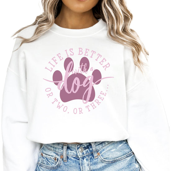 Close-up of 'Life is Better with a Dog or Two or Three' printed design on white sweatshirt