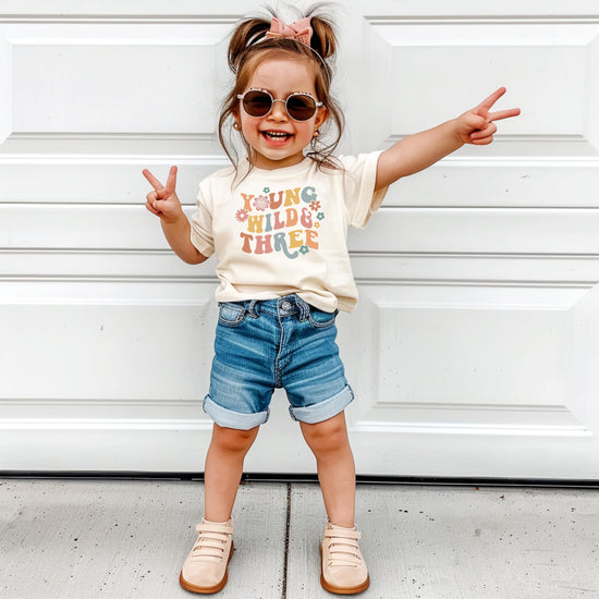 Toddler modeling Young Wild Three groovy birthday outfit complete look