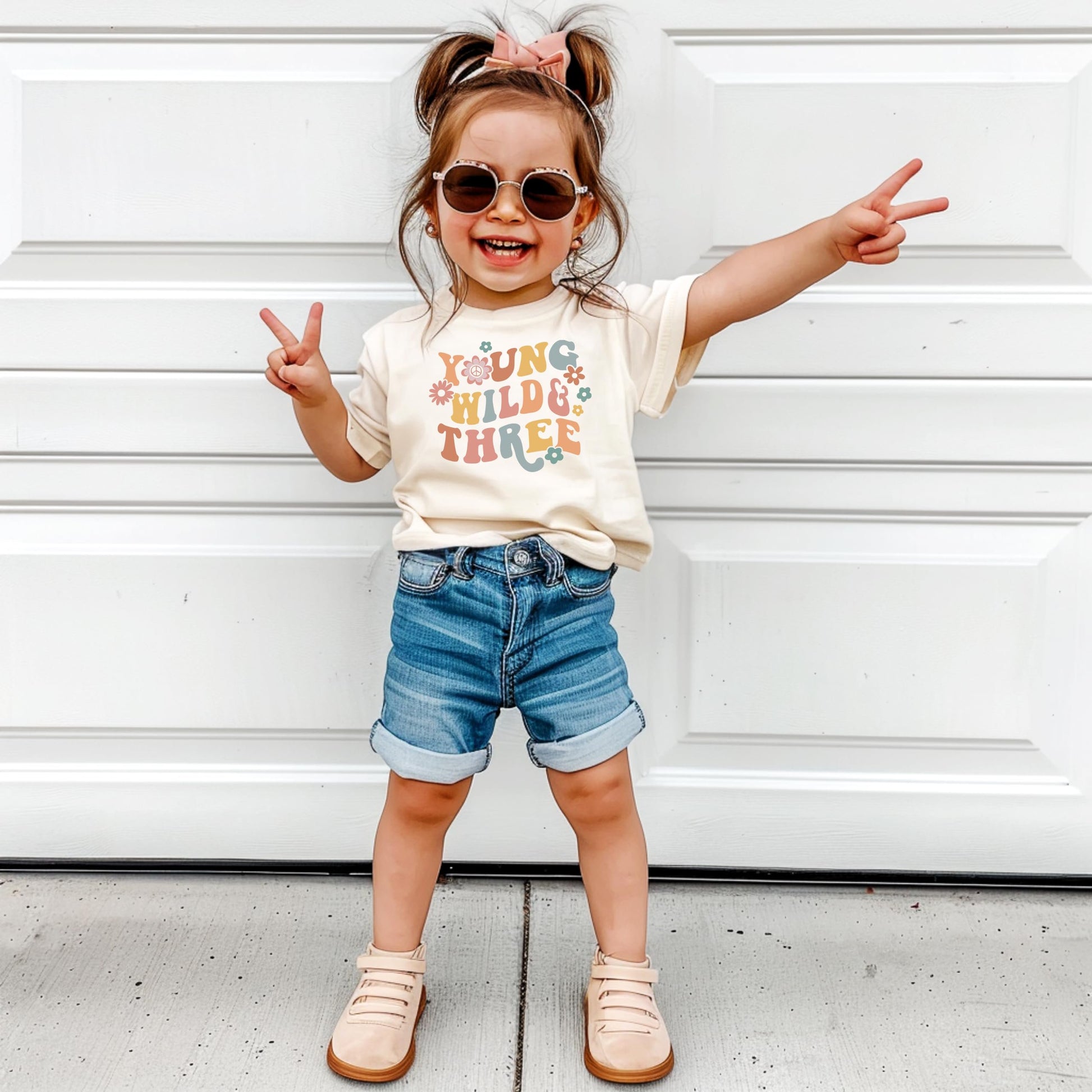 Toddler modeling Young Wild Three groovy birthday outfit complete look