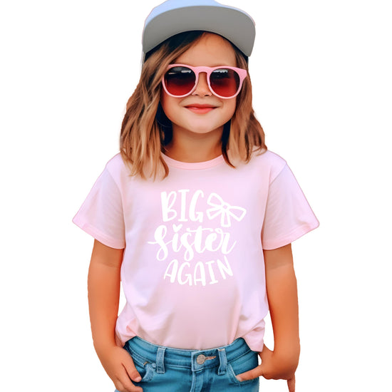 Detail shot of bow graphic on mauve Big Sister Again sibling reveal tee for girls