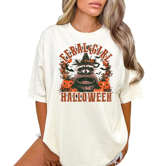 Seafoam green women's t-shirt featuring a raccoon in a witch hat with the text Feral Girl Halloween