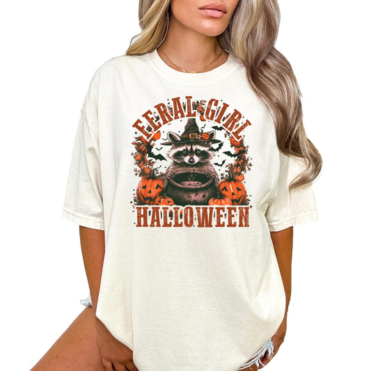Seafoam green women's t-shirt featuring a raccoon in a witch hat with the text Feral Girl Halloween