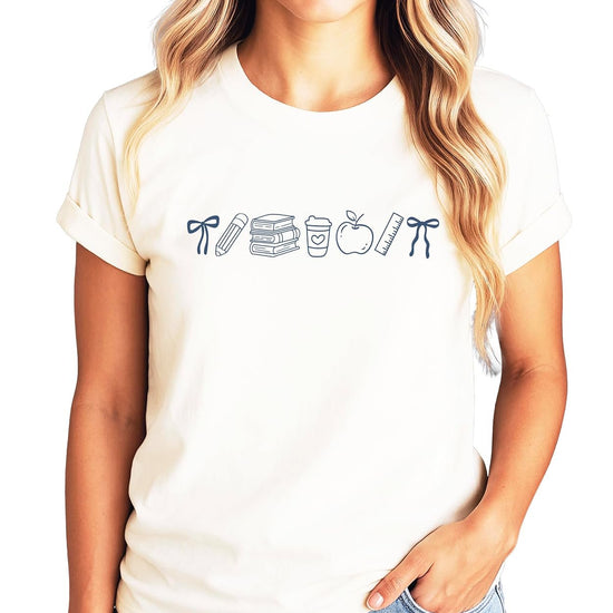 Front view of pink school supplies graphic tee with coquette bow design, shown on adult female model