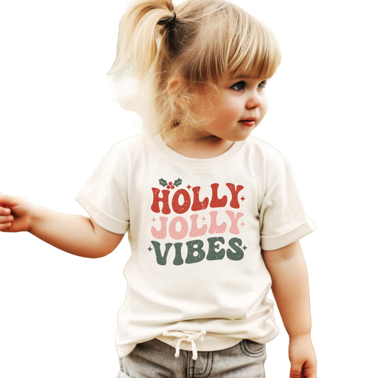 Close-up of Holly Jolly Vibes graphic print on natural Christmas tee from Olive Loves Apple