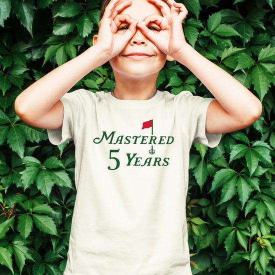 Close-up of Mastered 5 Years golf birthday graphic print on kids natural tee