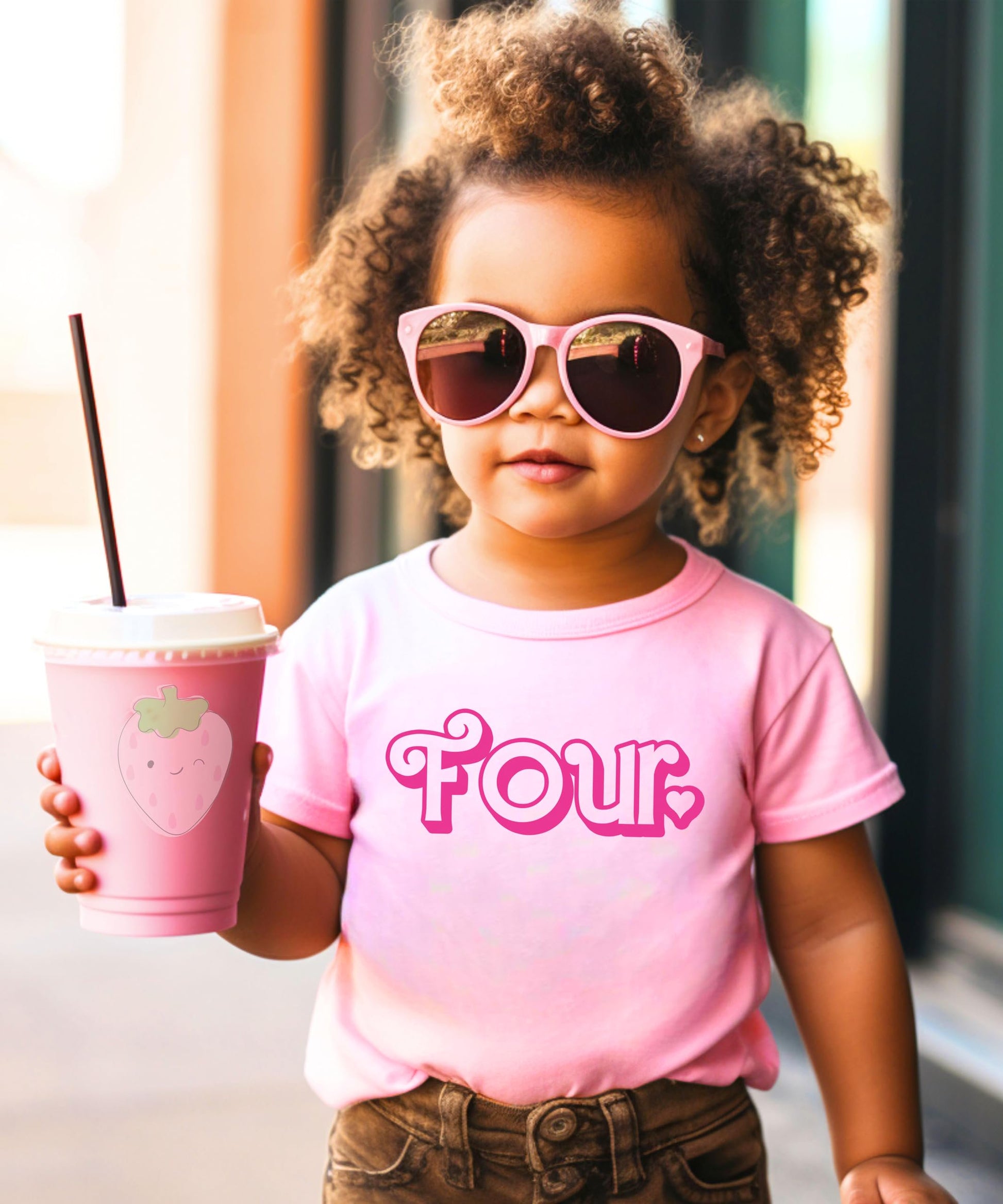 Flat lay of pink age four birthday shirt with cute girly heart print