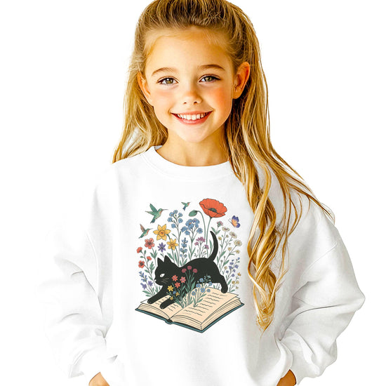 Adult wearing white black cat book lover sweatshirt with whimsical floral bookworm graphic on front