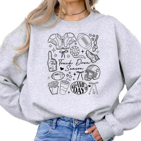 Woman wearing gray Touch Down Season football sweatshirt showing relaxed fit and style