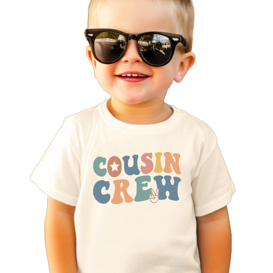 Natural colored kids t-shirt with colorful retro Cousin Crew text and peace sign design