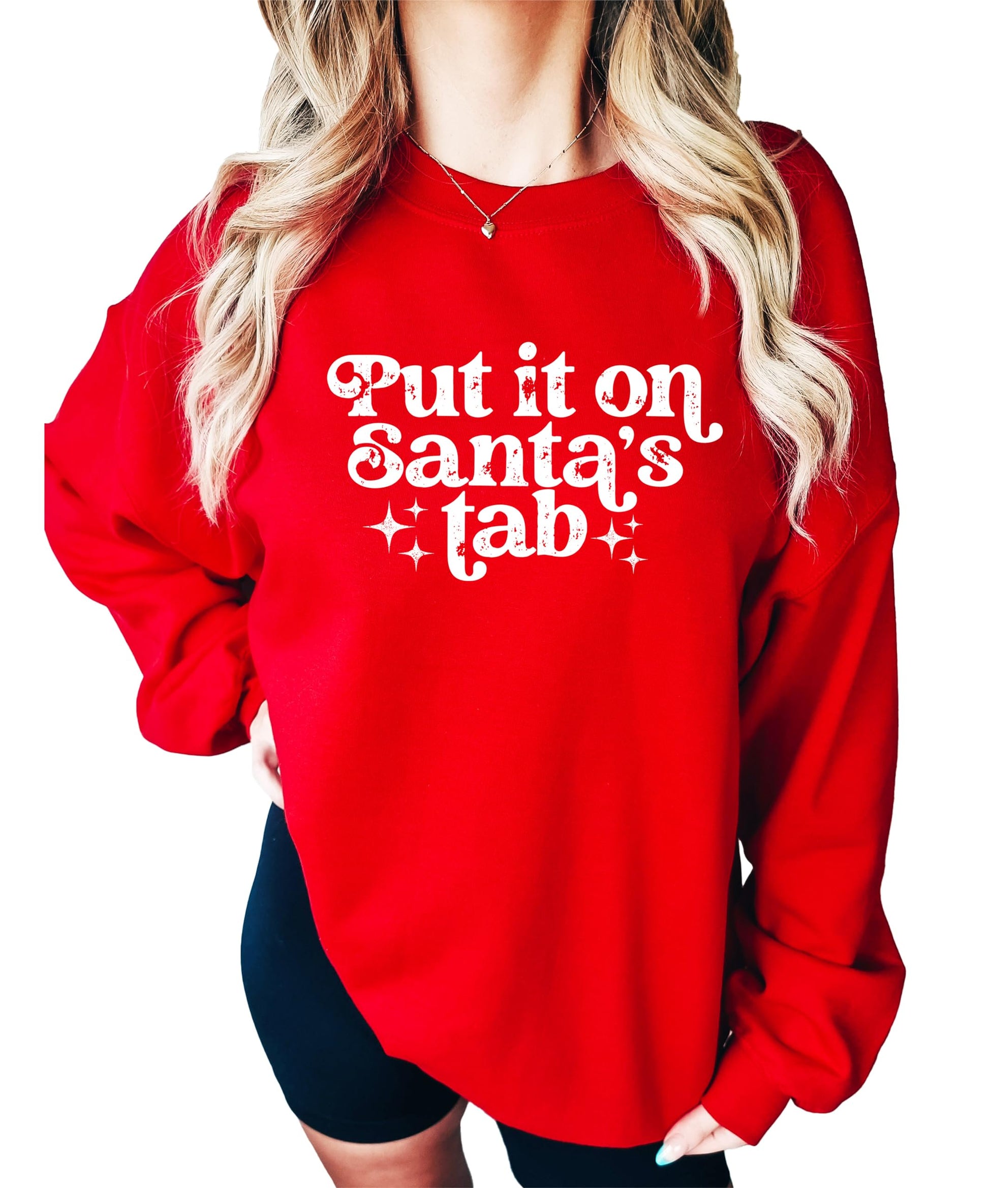 Close-up of 'Put It on Santa's Tab' graphic print detail on red women's Christmas sweatshirt